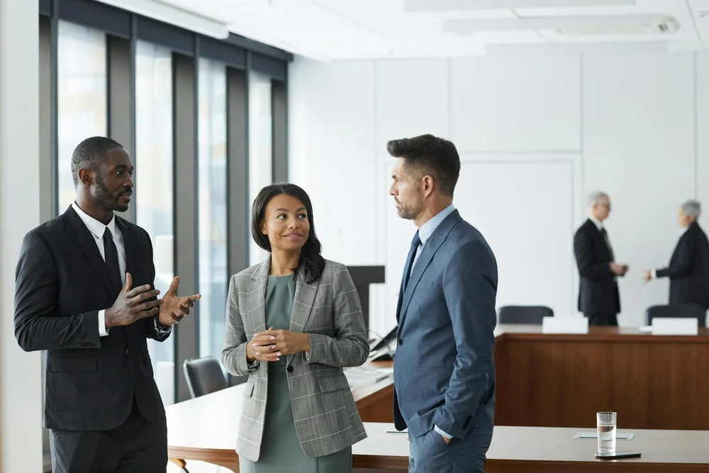 Three business professionals in discussion in a conference room.”